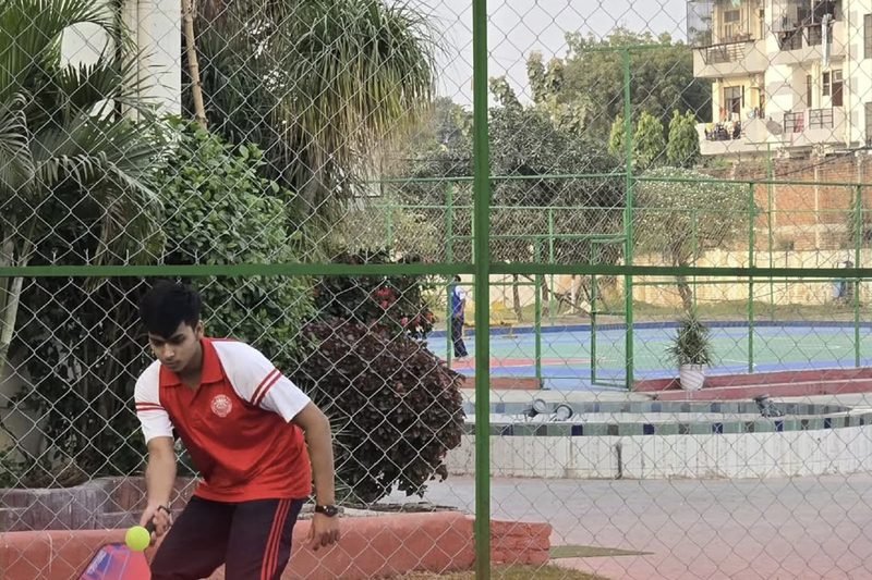 A student playing pickleball on the outdoor court at Dalimss Sunbeam Rohania