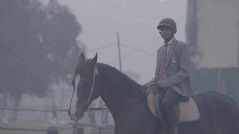 Student in riding helmet on horseback