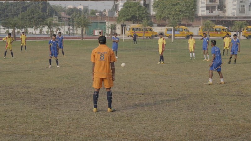 Students playing football on the main playing field, Rohania