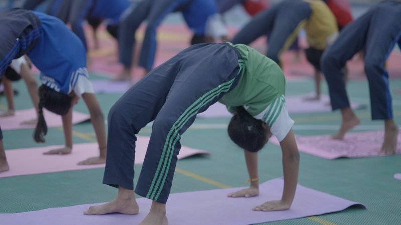 Students holding the wheel pose in a yoga session, Rohania
